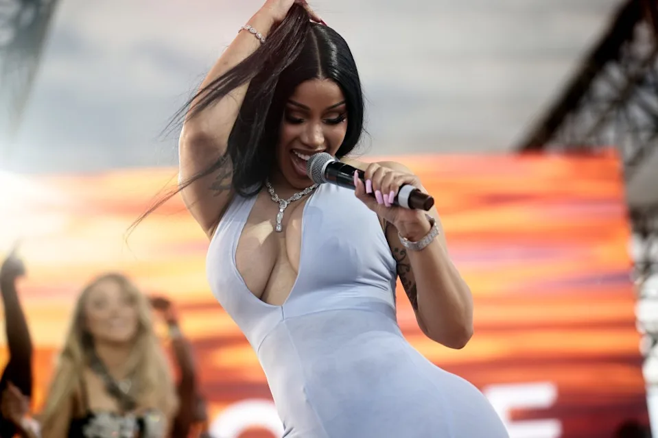 Cardi B performing live on stage in New Jersey, delivering a vibrant concert with dancers, lights, and an energetic crowd